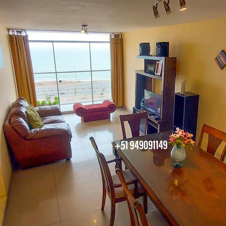 sala de estar con mesa y sofá en FRENTE AL MAR en SAN MIGUEL Apartamento LIMA CHECK IN, en Lima