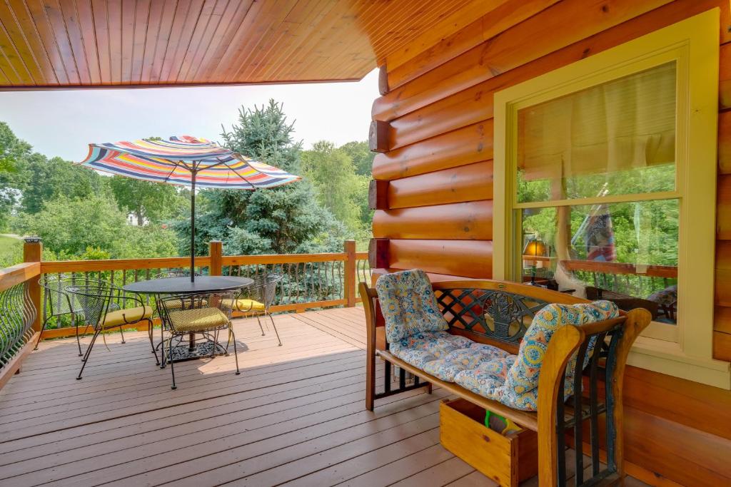 een veranda met een tafel en stoelen en een parasol bij Lakewood Lodge Escape with Fire Pit and Lake Access! in Hiwassee