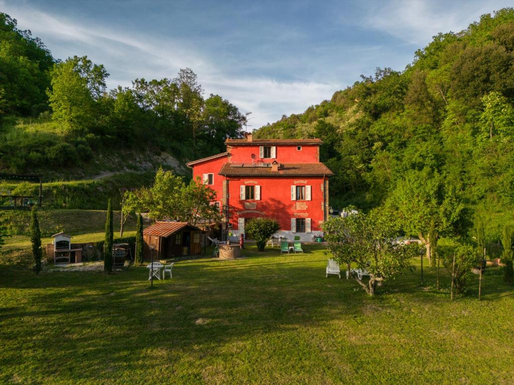 una grande casa rossa in mezzo a un campo di Il giaggiolo a Reggello