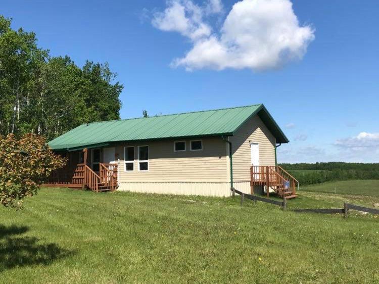 a small house with a green roof in a field at HI Rossburn 9 Finger Ranch in Rossburn