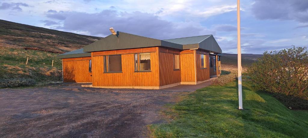 una cabaña de madera en medio de un campo en Guesthouse Klambrasel, en Skogar