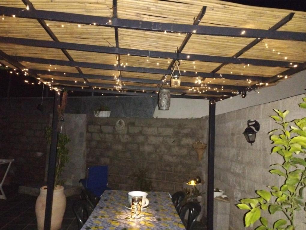 un patio con una mesa con luces. en Casa Flavia en Porto Pino