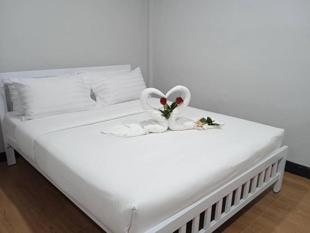 uma cama com dois cisnes feitos de toalhas em NK Guesthouse 1 em Klong Toi