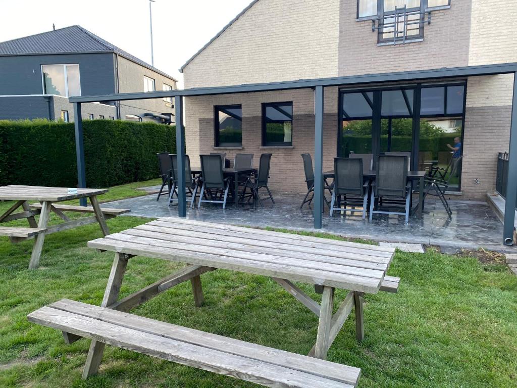 a group of picnic tables and chairs in a yard at Vakantiehuis Villa 1 - 11 beds, 17p, 2 Bath-, 1 Livingroom in Houthalen-Helchteren