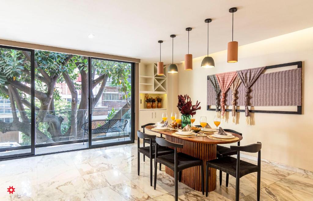 comedor con mesa, sillas y ventanas grandes en Villa Sócrates by Kukun, en Ciudad de México