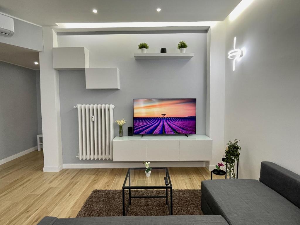 sala de estar con TV de pantalla plana en la pared en Luxury Downtown - Milan MF Apartments, en Milán