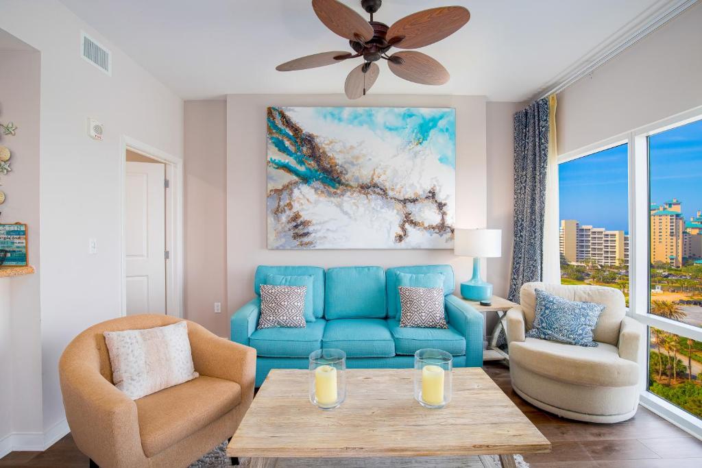 a living room with a blue couch and chairs at Luau 7010 in Destin