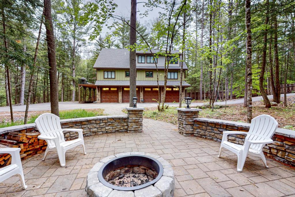 un patio con sillas y una hoguera frente a una casa en Webb River House en Rumford