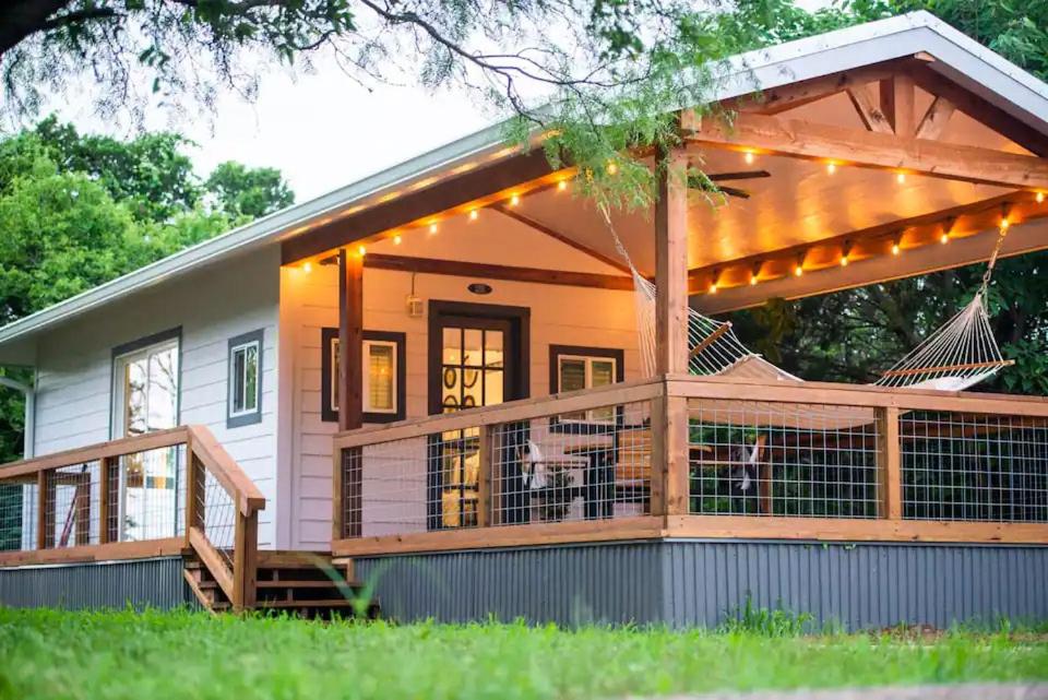 une maison avec une terrasse et une véranda éclairée dans l'établissement Bluebonnet Trail, à Waco