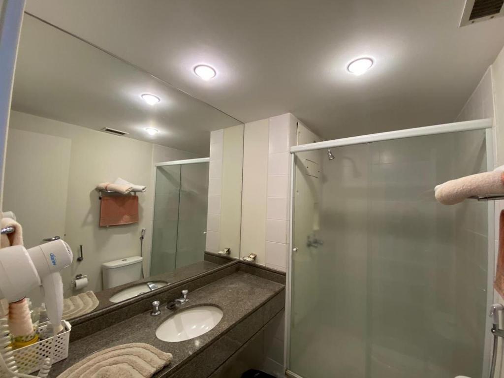 uma casa de banho com um lavatório e um chuveiro com um espelho. em Hotel Aeroporto Congonhas em São Paulo