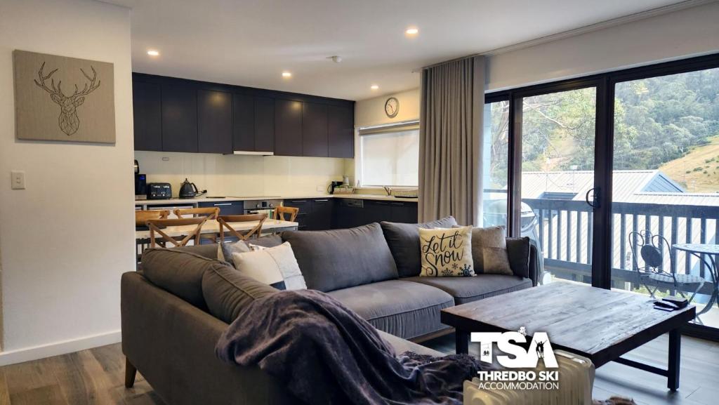 a living room with a couch and a table at Mowamba B2 in Thredbo