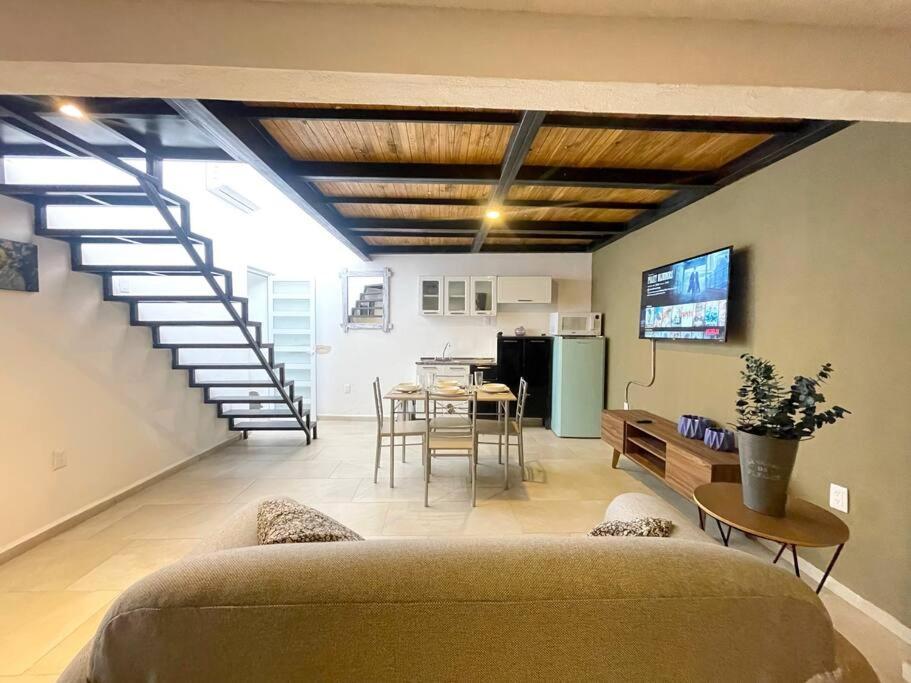 uma sala de estar com um sofá, uma mesa e uma escada em Departamento Polanco 6 em San Luis Potosí