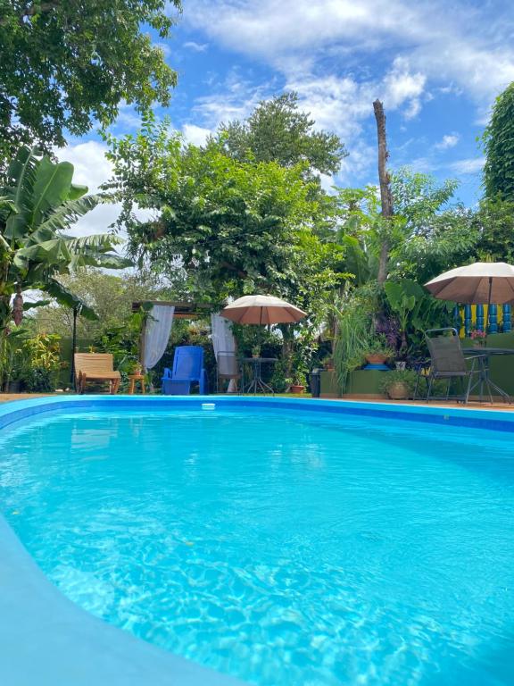 uma grande piscina azul com guarda-sóis em Pequeno Paraíso em Foz do Iguaçu