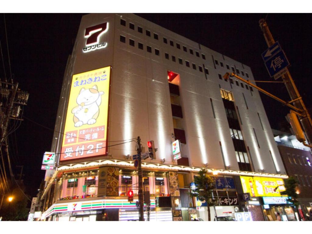 duży budynek z znakiem na nim w nocy w obiekcie SEVEN Building / Vacation STAY 4953 w mieście Asahikawa