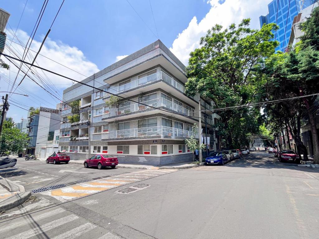 un edificio de apartamentos en una calle con coches aparcados en Mi Zona Lodging WTC en Ciudad de México