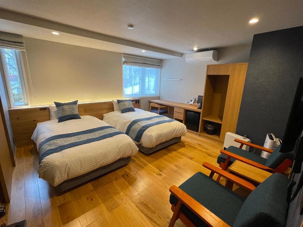 una habitación de hotel con 2 camas y una silla en Little Grebe, en Chino