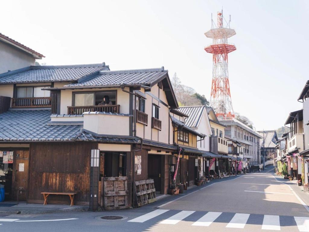 eine Straße in einer Stadt mit einem Turm im Hintergrund in der Unterkunft 竹田まちホテル in Taketa