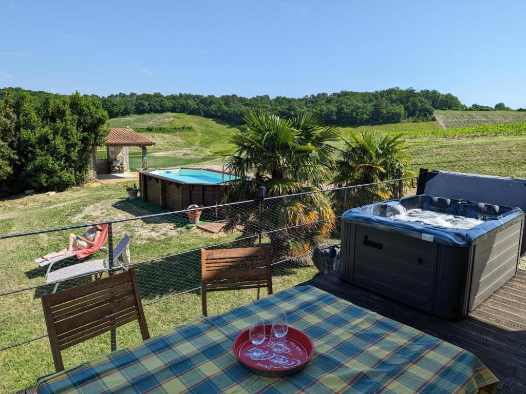 einen Tisch und Stühle auf einem Balkon mit Pool in der Unterkunft Gîte Montignac-le-Coq, 3 pièces, 6 personnes - FR-1-653-4 in Montignac-le-Coq