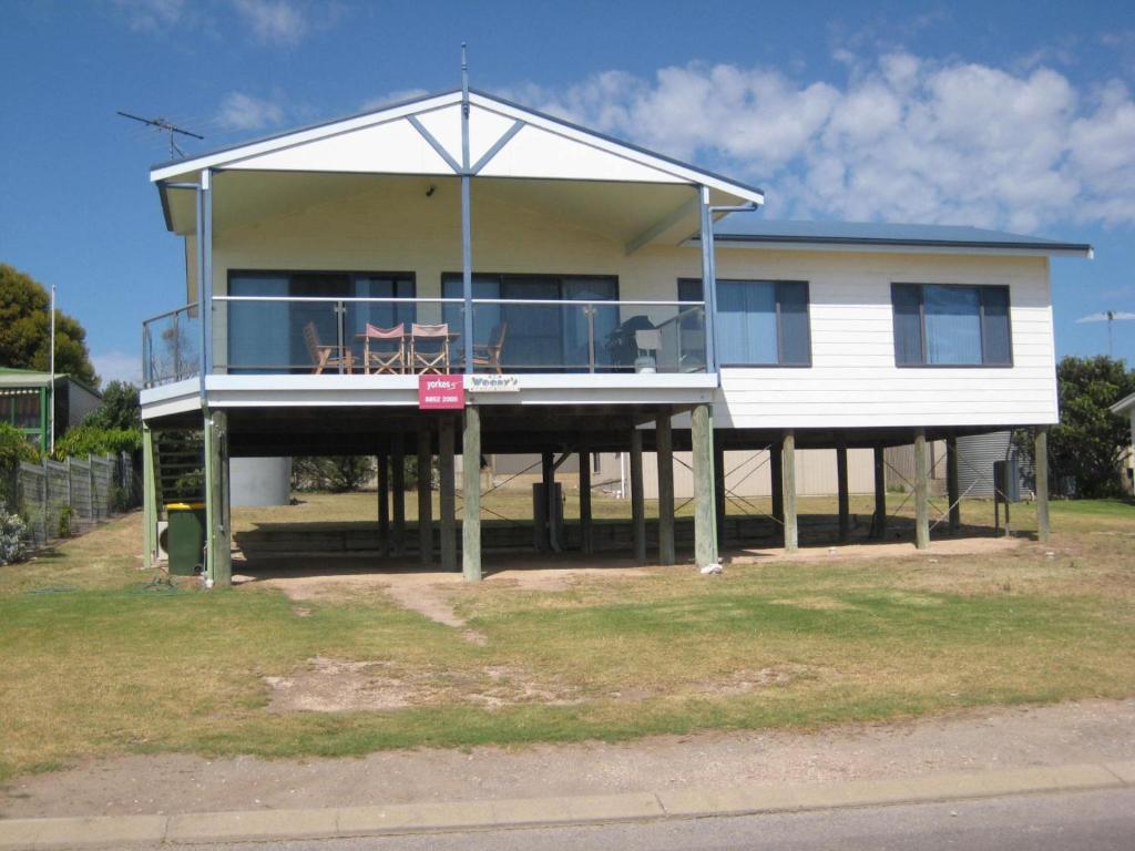 ein Haus auf Stelzen mit einer großen Terrasse in der Unterkunft Woody's Beach House in Point Turton