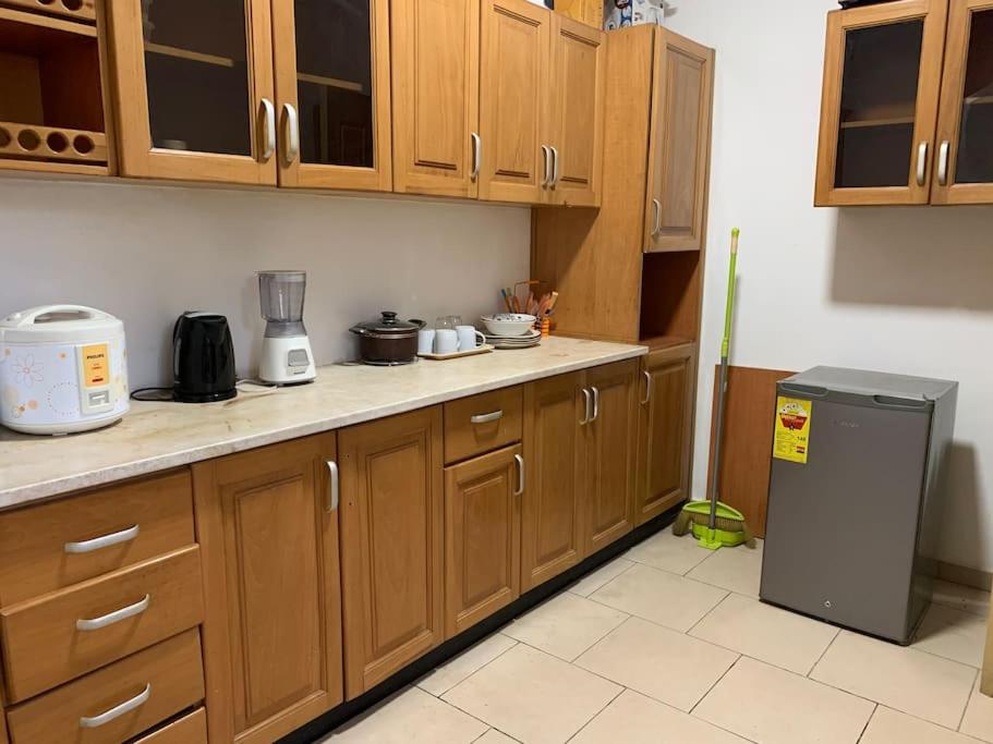 - une cuisine avec des placards en bois et un réfrigérateur dans l'établissement 2 Bedroom @ Devtraco Estates -Tema Comm 25, à Tema