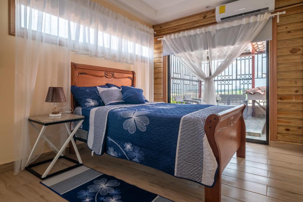 a bedroom with a bed and a window and a table at Loft con terraza en Santo Domingo in La Estrella
