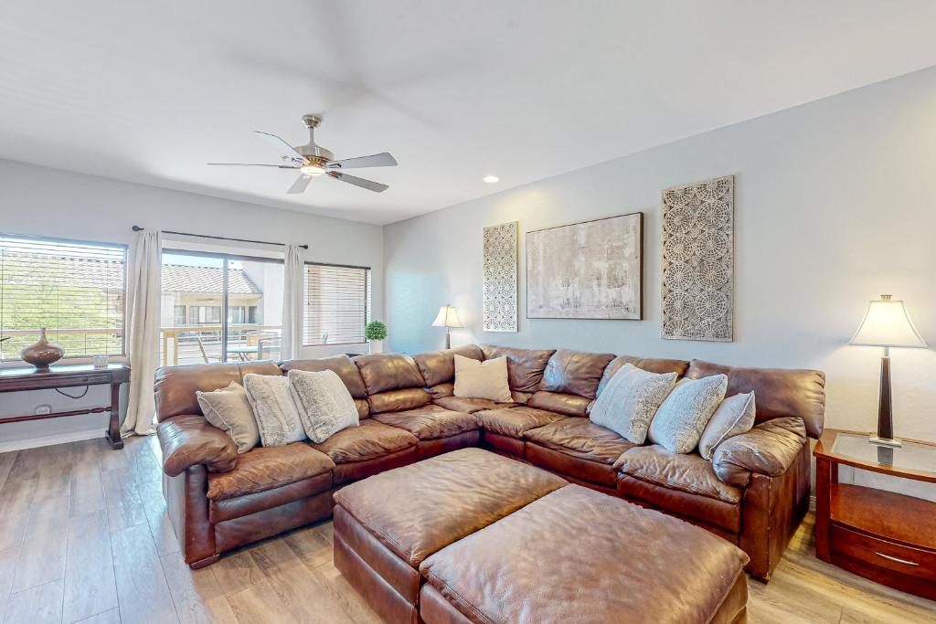 un soggiorno con divano in pelle marrone di A Slice of Scottsdale Serenity a Scottsdale