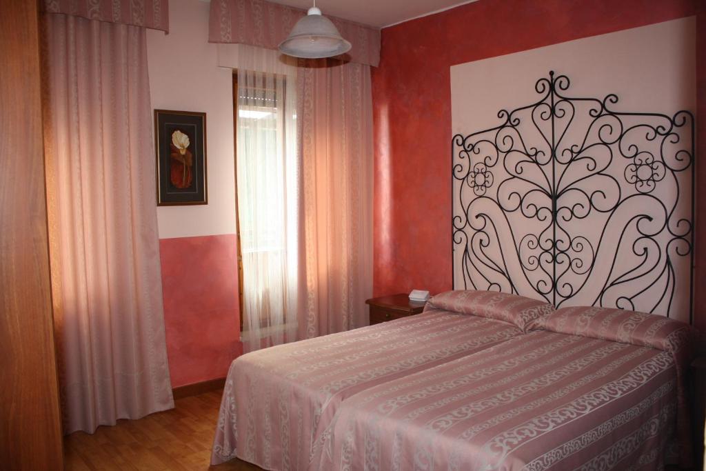 レコアーロ・テルメにあるLocanda Seggioviaの赤い壁のベッドルーム1室(ベッド1台付)