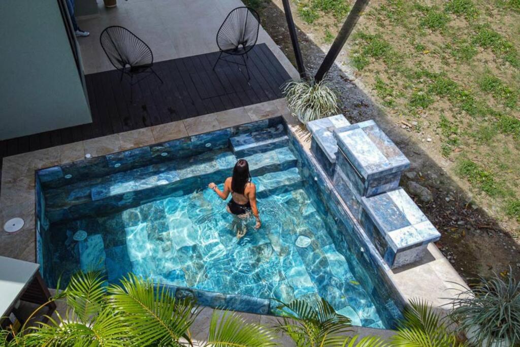 a woman is standing in a swimming pool at Villa Aurora with Jacuzzi in La Fortuna in Fortuna