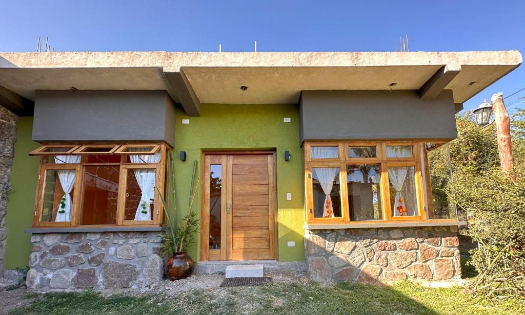 Casa verde con puertas y ventanas de madera en La Pichonita en Lozano