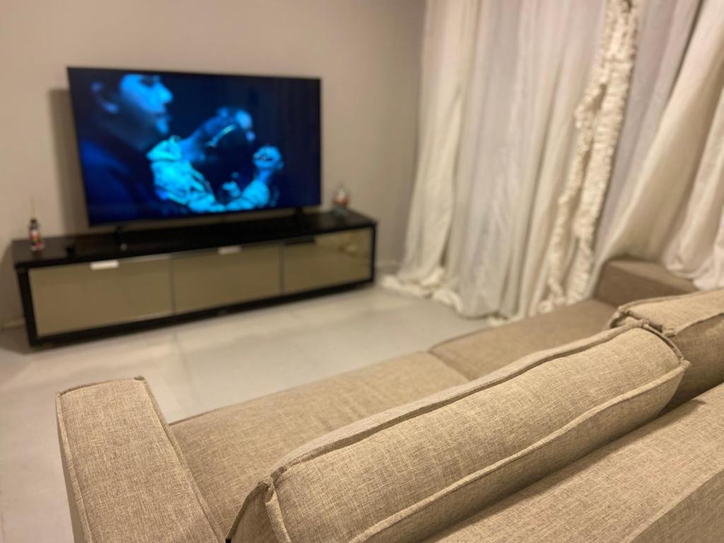 a living room with a couch and a flat screen tv at Loft na Serra Catarinense in São Joaquim