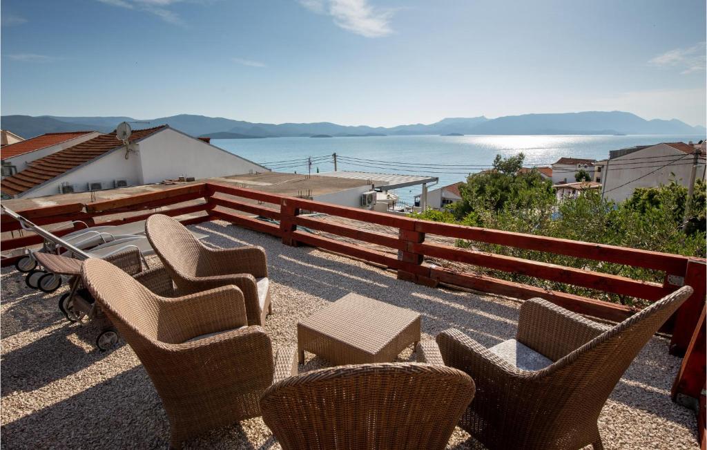 a group of chairs and tables on top of a balcony at 1 Bedroom Stunning Apartment In Komarna in Klek