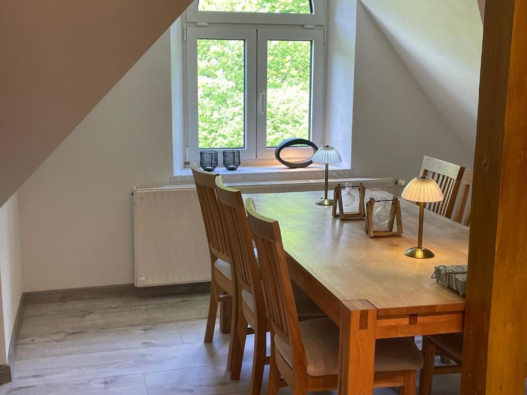 - une salle à manger avec une table et des chaises en bois dans l'établissement FeWo am Fusse der Landeskrone mit Sauna, à Görlitz