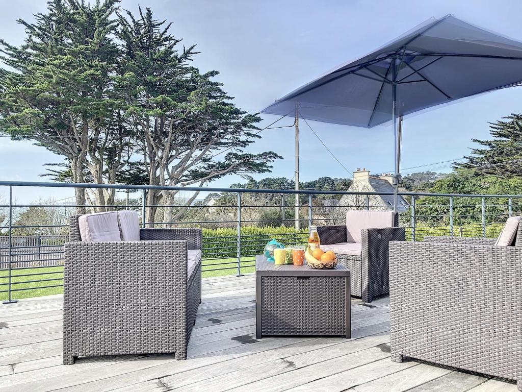 a patio with two chairs and an umbrella at Maison Crozon, 4 pièces, 6 personnes - FR-1-370-37 in Crozon