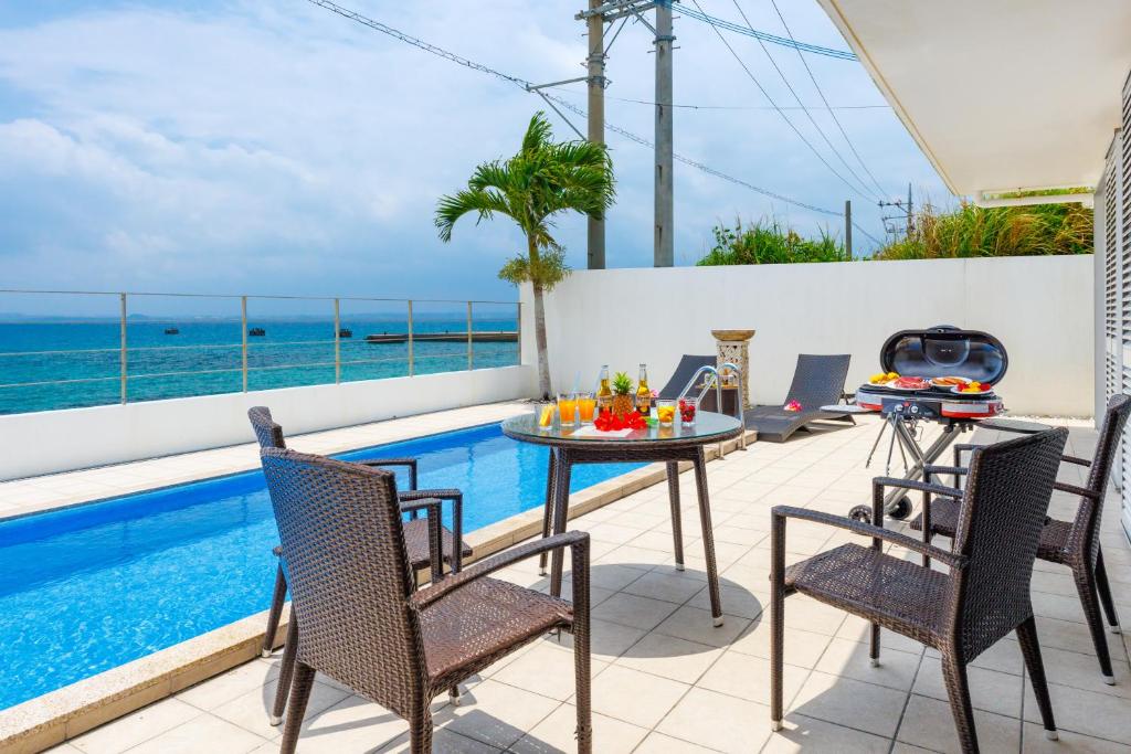 un patio con mesa y sillas junto a una piscina en Coldio Marina Kin B032 en Kin