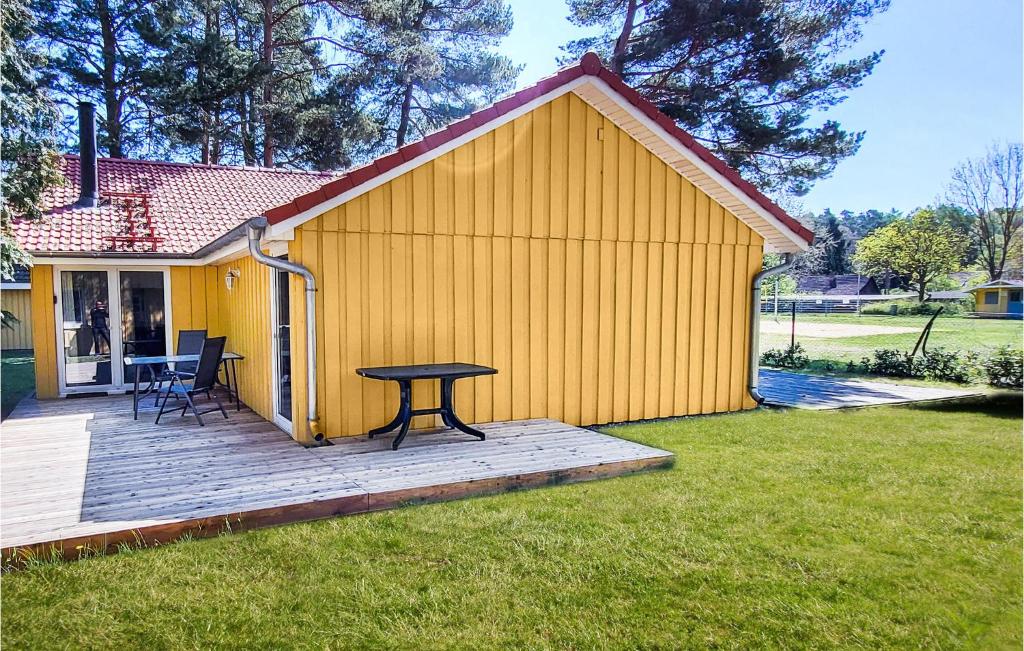 a yellow building with a picnic table on a deck at Stunning Home In Mirow Ot Granzow With Kitchen in Granzow