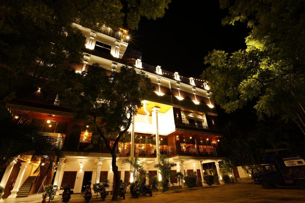 a lit up building at night with motorcycles parked in front at J Hotel in Jaffna