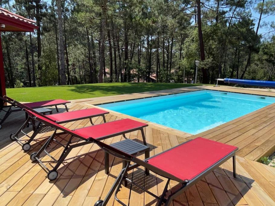 une terrasse avec deux tables de pique-nique et une piscine dans l'établissement Maison 5 personnes avec piscine privée chauffée - Private heated pool 5 people house - Moliets-et-Maa - Landes - France, à Moliets-et-Maa