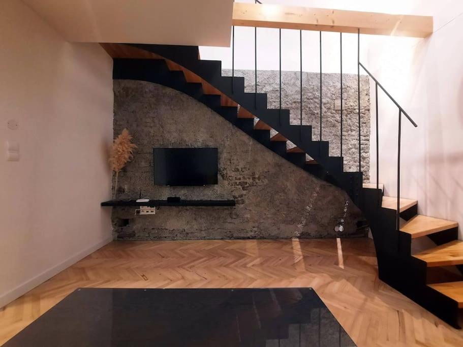 a living room with a staircase and a tv at Buda-city house in Trnávka