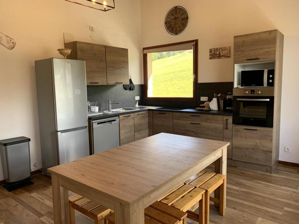 a kitchen with a wooden table and a refrigerator at Duplex 6 pers, proche pistes, casier à skis, parking - FR-1-733-81 in Crest-Voland