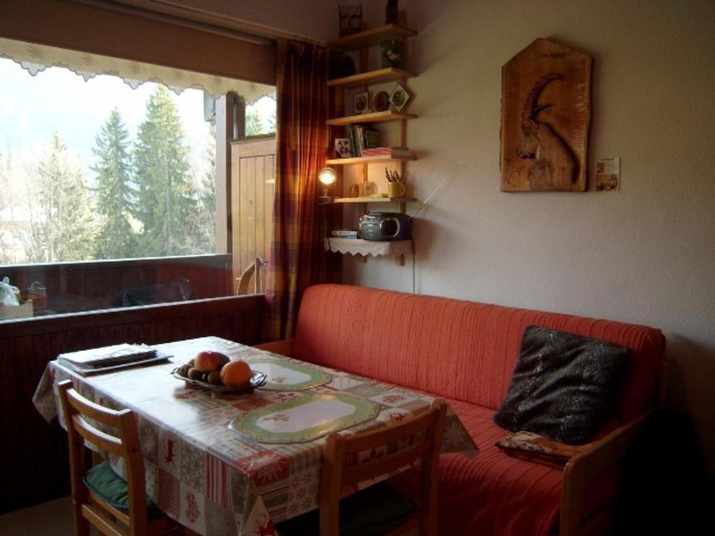 a living room with a table and a red couch at Appartement Crest-Voland, 1 pièce, 4 personnes - FR-1-733-113 in Crest-Voland