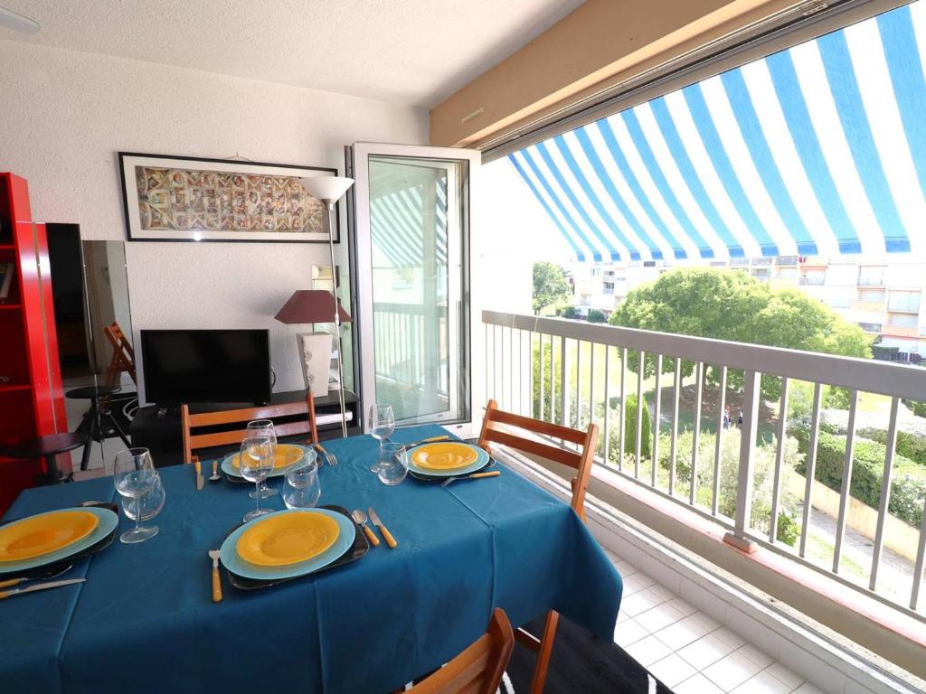 ein Esszimmer mit einem blauen Tisch und einem Balkon in der Unterkunft Appartement Le Grau-du-Roi, 2 pièces, 4 personnes - FR-1-307-240 in Le Grau-du-Roi