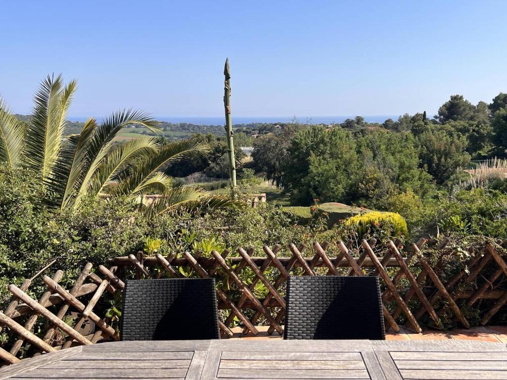 deux chaises assises devant une clôture en bois dans l'établissement Mas 3 chambres avec piscine, clim, Wi-Fi et tennis - FR-1-726-29, à La Croix-Valmer