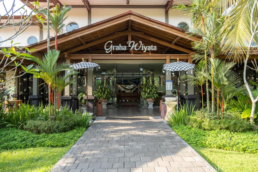 a store front of a resort with palm trees at Graha Wiyata in Tanah Lot