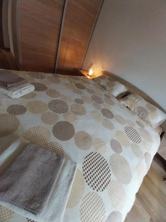 un letto con copriletto bianco e marrone. di F&M Apartment No 18 a Skopje