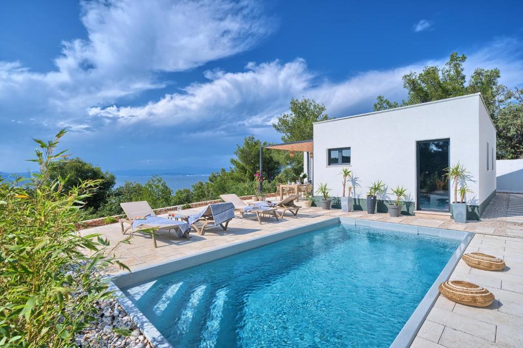 una piscina con sillas y una casa en Holiday house Sunset Haven Estate en Sutivan