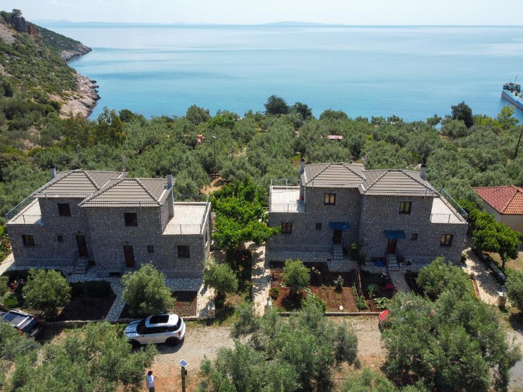 an aerial view of two houses with the ocean in the background at Astros Beach house within an olive farm in Astros