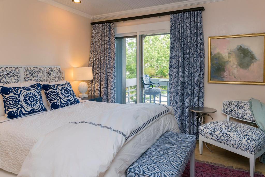 a bedroom with a bed and a chair and a window at 2465 Racquet Club Villa in Seabrook Island