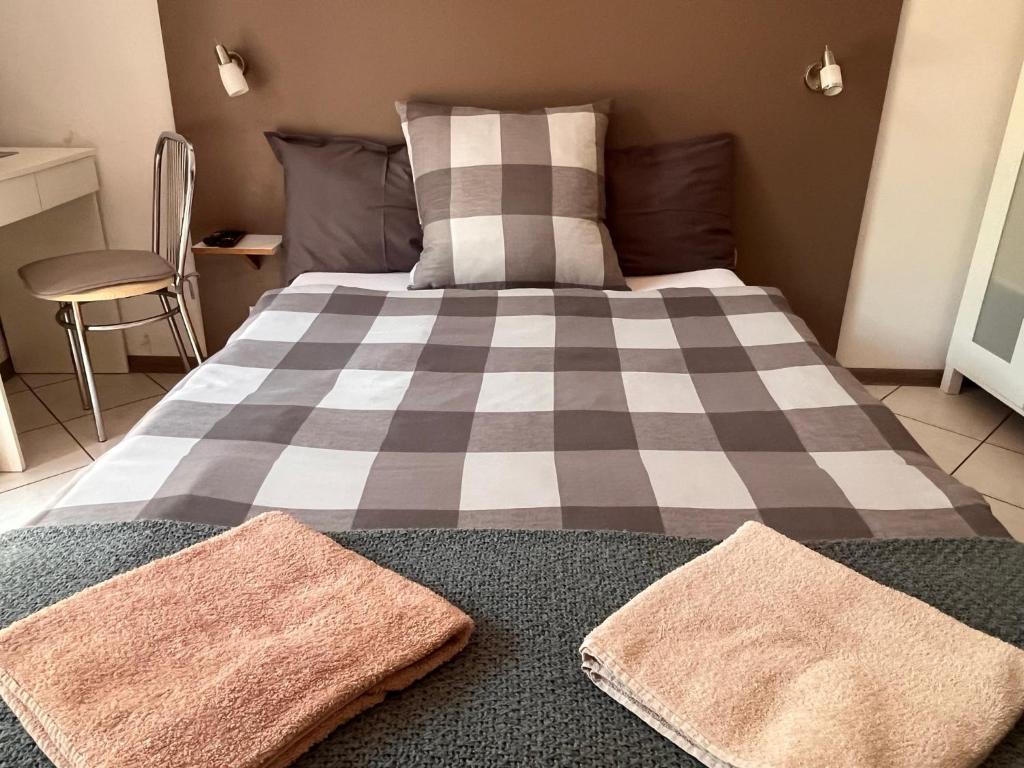 a bedroom with a bed with two towels on it at White Garden in Oświęcim