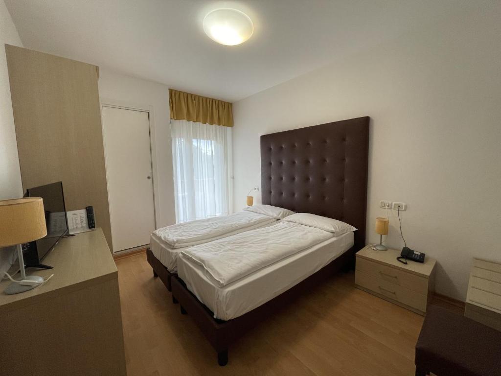 Postel nebo postele na pokoji v ubytování Hotel Garni Losanna