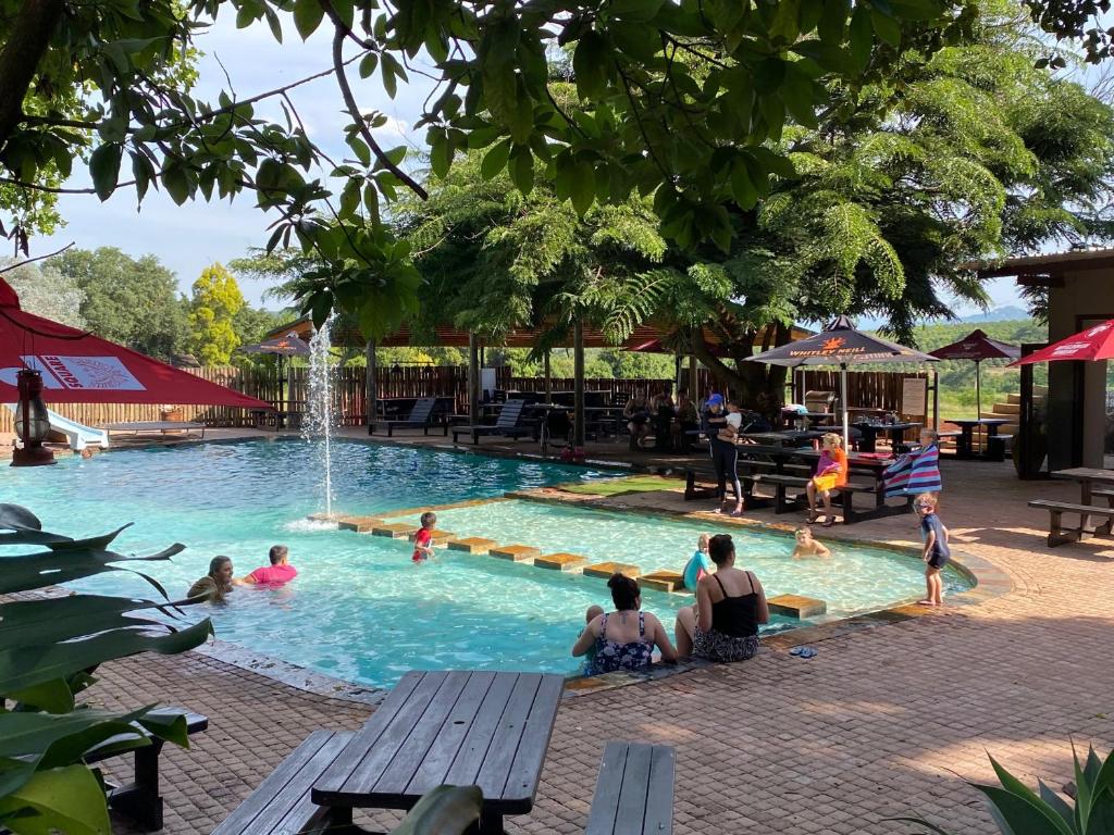 um grupo de pessoas sentadas numa piscina em El Roi Guest Lodge em White River